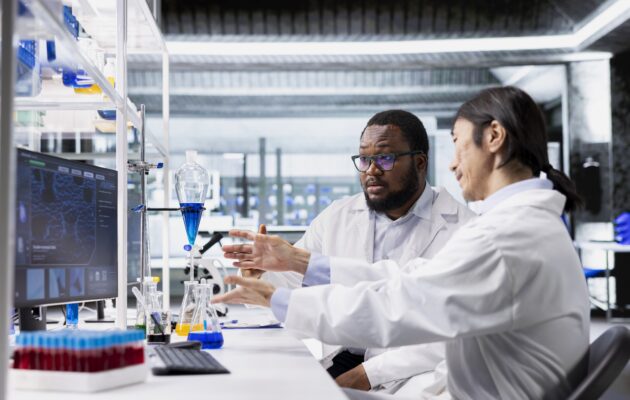 Two scientist are a lab station.